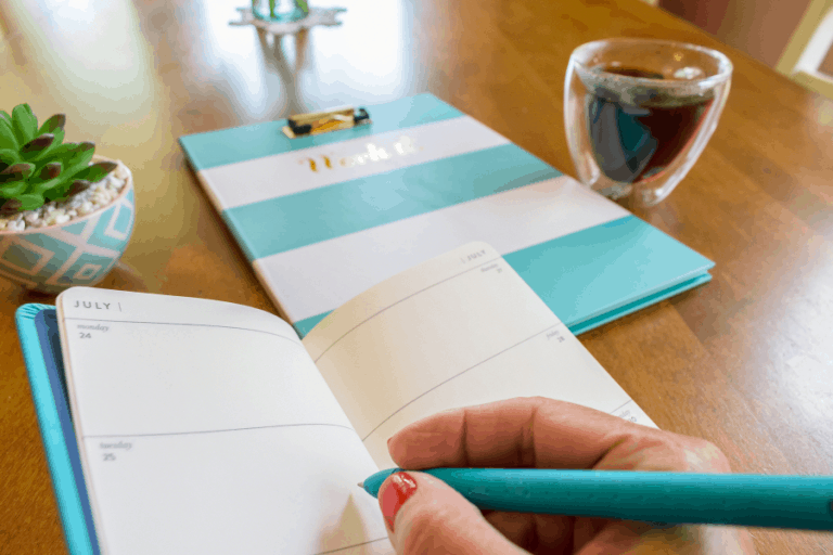 woman writing in a blue planner