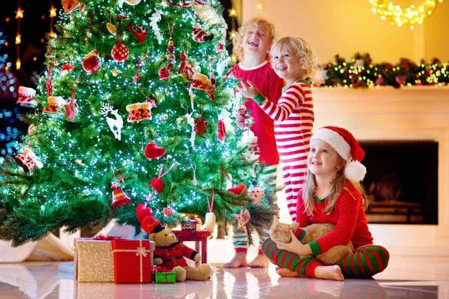 kids standing around a christmas tree